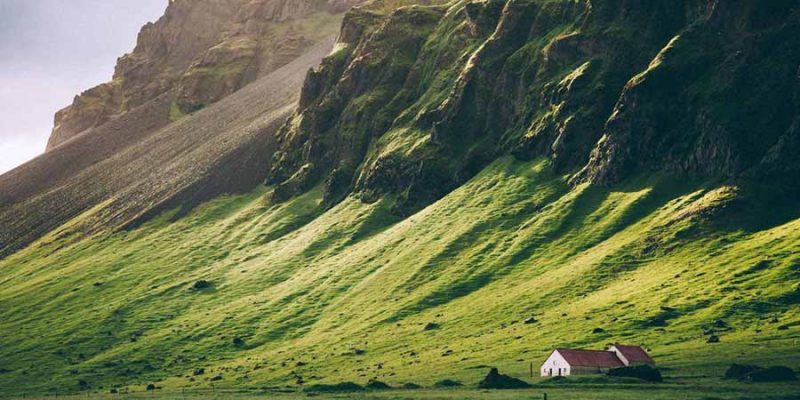 IJsland-in-de-zomer-huisje-tegen-groene-berg