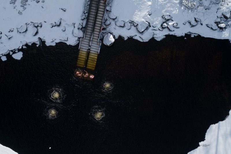 Afkoelen in een icehole na de sauna.