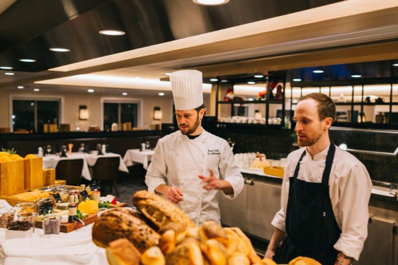 Restaurantmedewerker en chefkok bij het buffet op het MS Spitsbergen