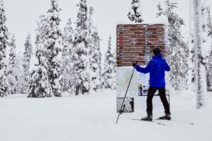 Een langlaufer bekijkt de bewegwijzering op de langlauf route.