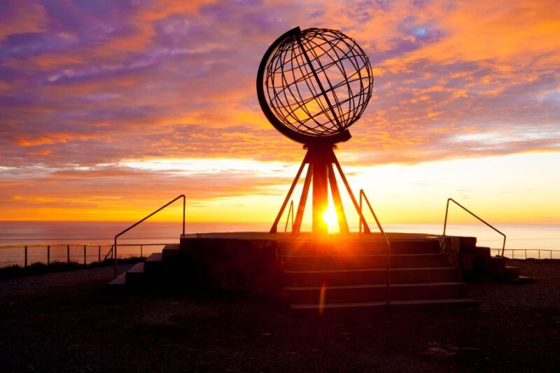 Zonsondergang aan monument op de Noordkaap in Noord-Noorwegen
