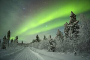 Het noorderlicht over een besneeuwd landschap in winters lapland met nordic