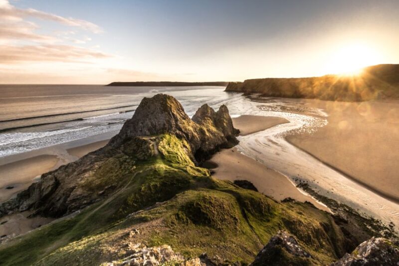 Panoramisch-van-zonsondergang-bij-Three-Cliffs-op-het-schiereiland-Gower-Zuid-Wales-VK