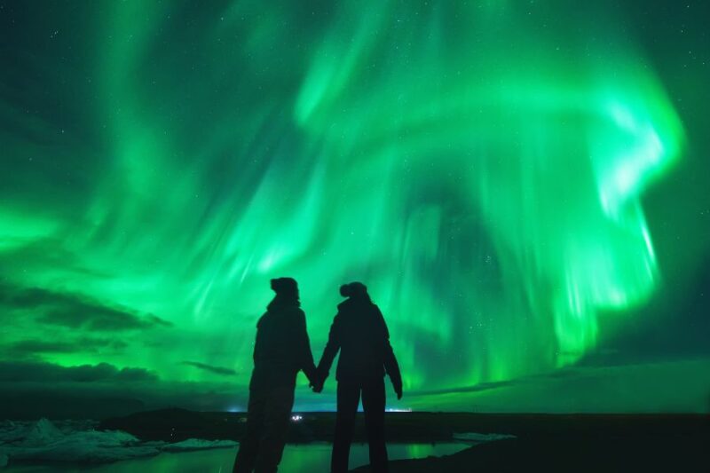 Een stel bewondert het noorderlicht in Lapland met Nordic, de Scandinaviëspecialist